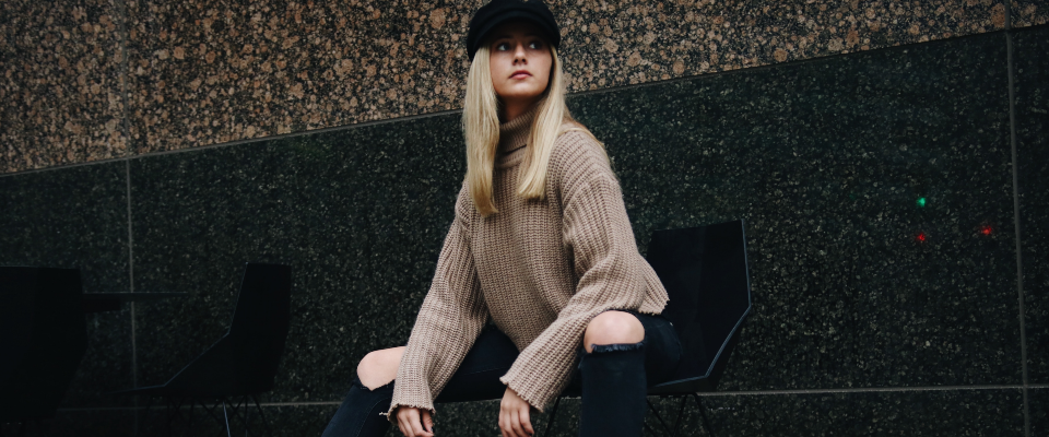 blonde woman with hat sat on bench